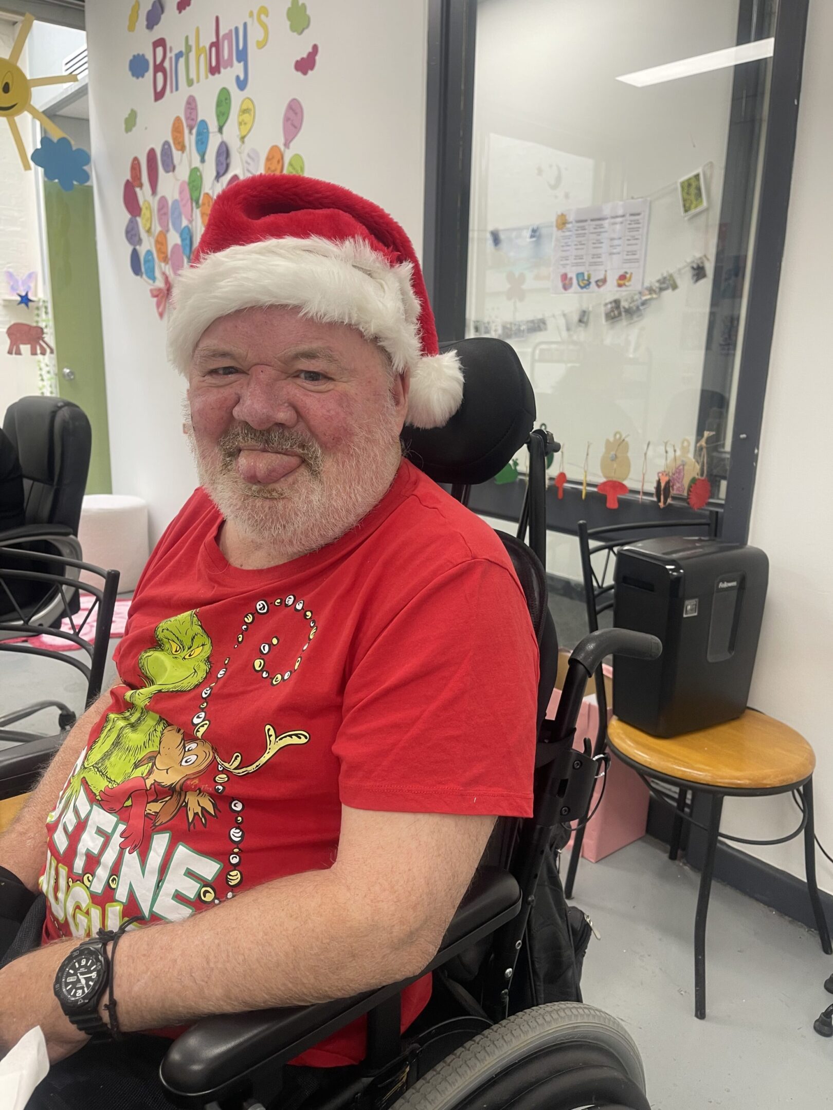 A man in a wheelchair wearing a santa hat.