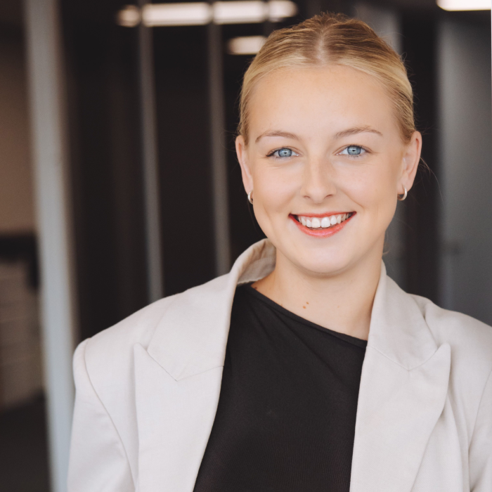 1 A woman in a white jacket smiling for the camera.