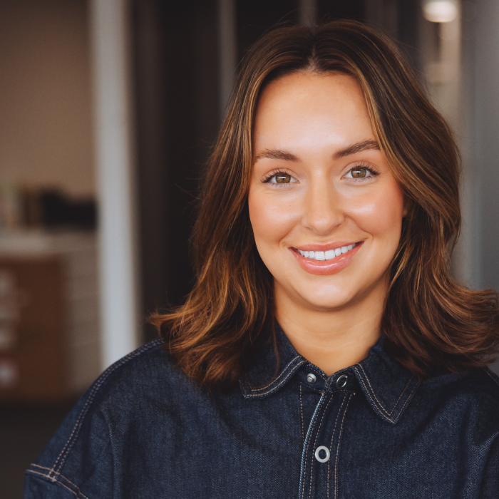 4 A woman in a blue shirt smiling for the camera.