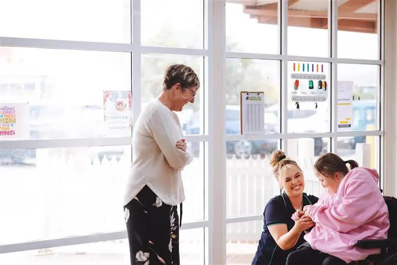 A group of women sitting in front of windows.