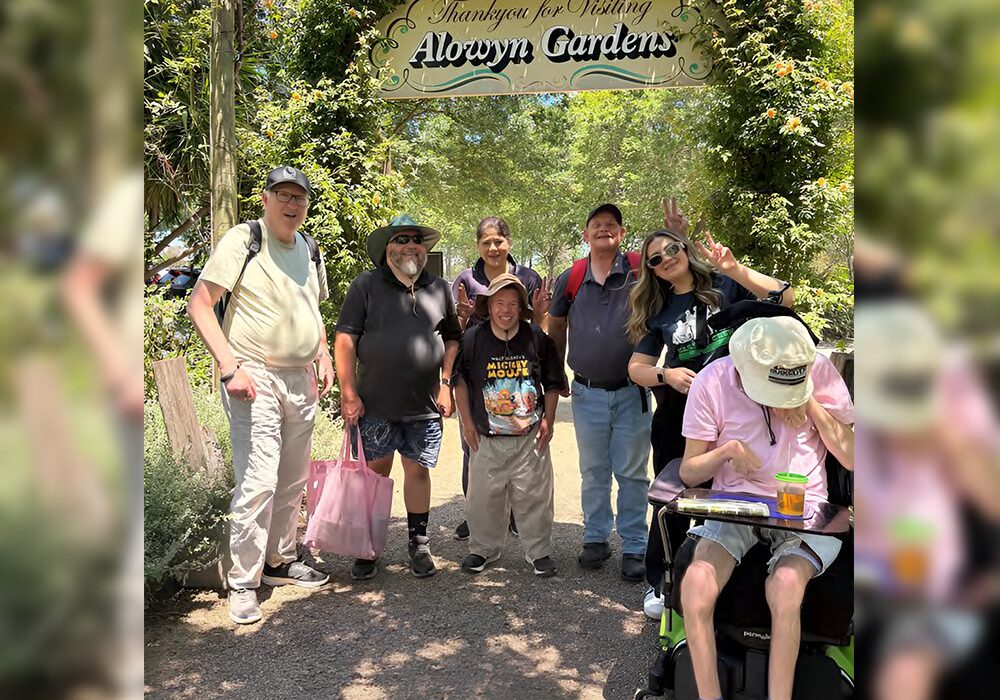 A group of people standing under an arbor.